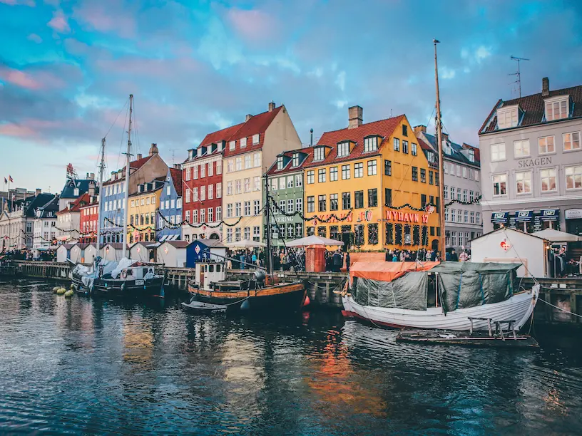 Farverige bygninger og både på vandet i københavn, danmark.
