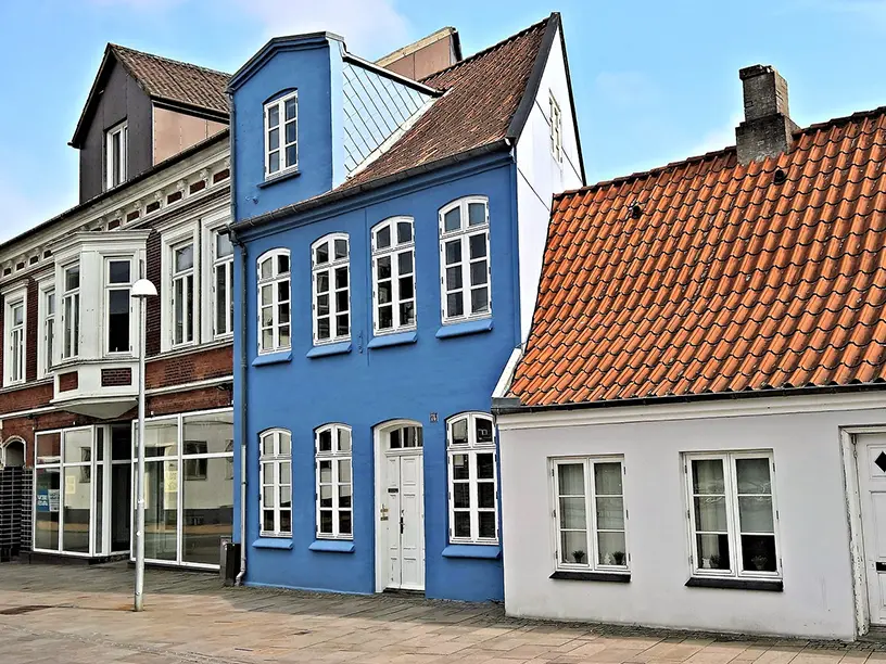 En række blå og hvide bygninger på en gade, der gennemgår ejendomsvurdering i 2022.