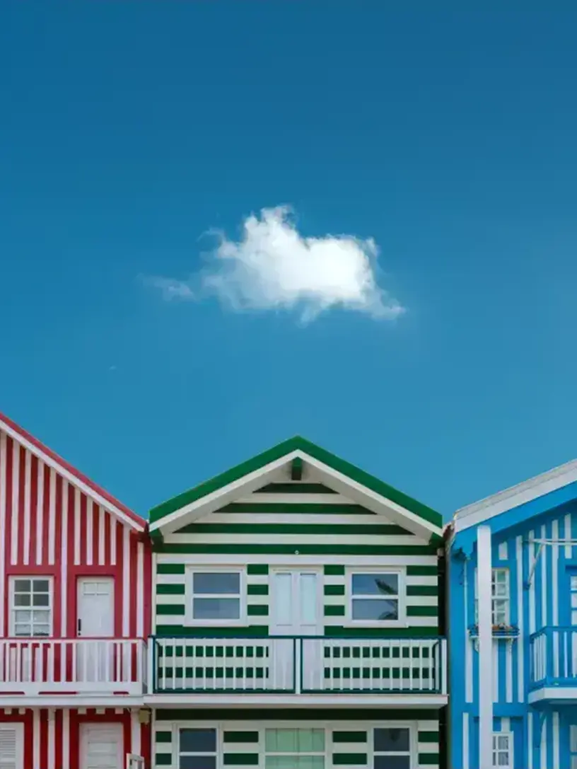 En række farverige huse med en blå himmel i baggrunden.